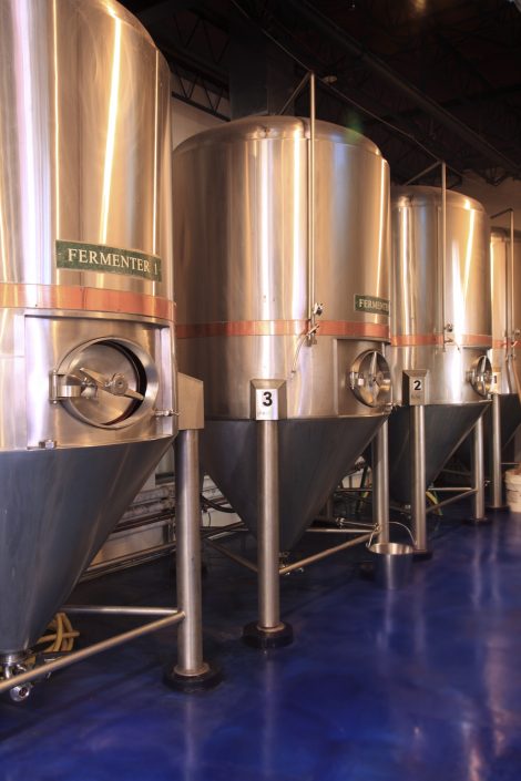Cobalt blue epoxy floors enhance the beauty of the stainless steel and copper brewery equipment.