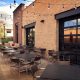 This image is Mickey Finn's outdoor patio, design elements include exposed steel frame and ten-foot garage style overhead doors that open to the dining room.