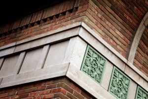 State Bank of The Lakes exterior oak leaf pattern green stone detail and brick & stone masonry.