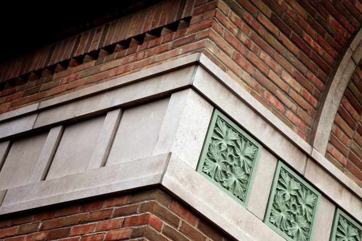 State Bank of The Lakes exterior oak leaf pattern green stone detail and brick & stone masonry.